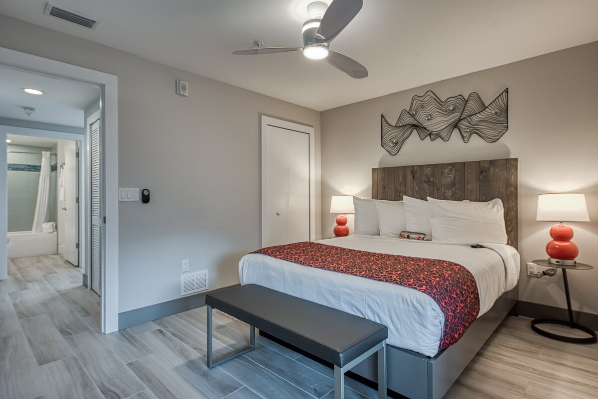 Contemporary king bedroom with modern furnishings and ensuite bathroom at FUSION Resort in Treasure Island, Florida.