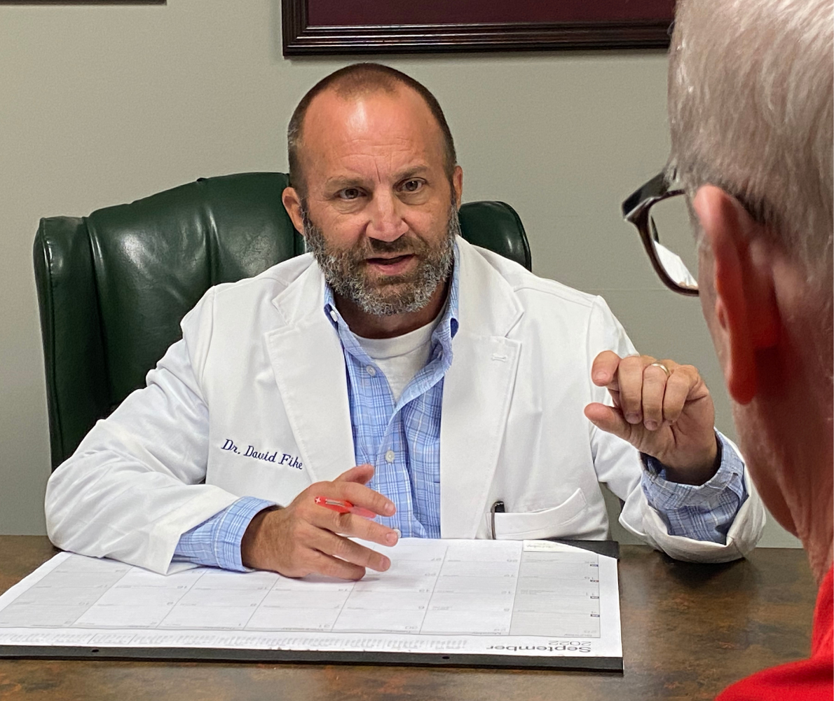 Chiropractor Dr. David Fike talks with a patient at Fike Chiropractic & Acupuncture - Tulsa