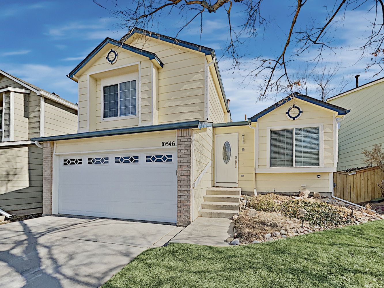 Front of home shot showcasing a two-car garage and steps up to front door at Invitation Homes in Denver.