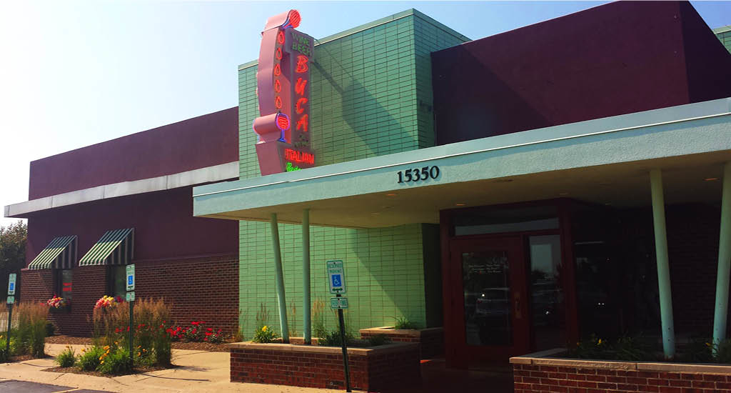The exterior of Buca di Beppo Orland Park shows the red building with red Buca sign on green accent.