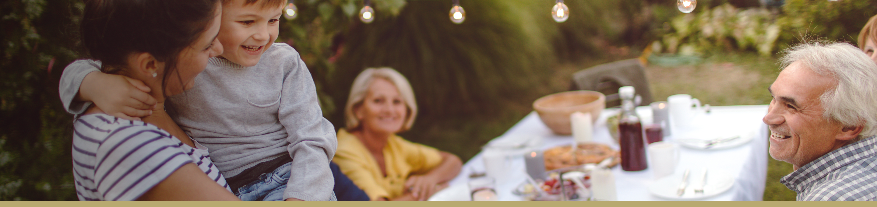 Happy family enjoying dinner in their backyard.