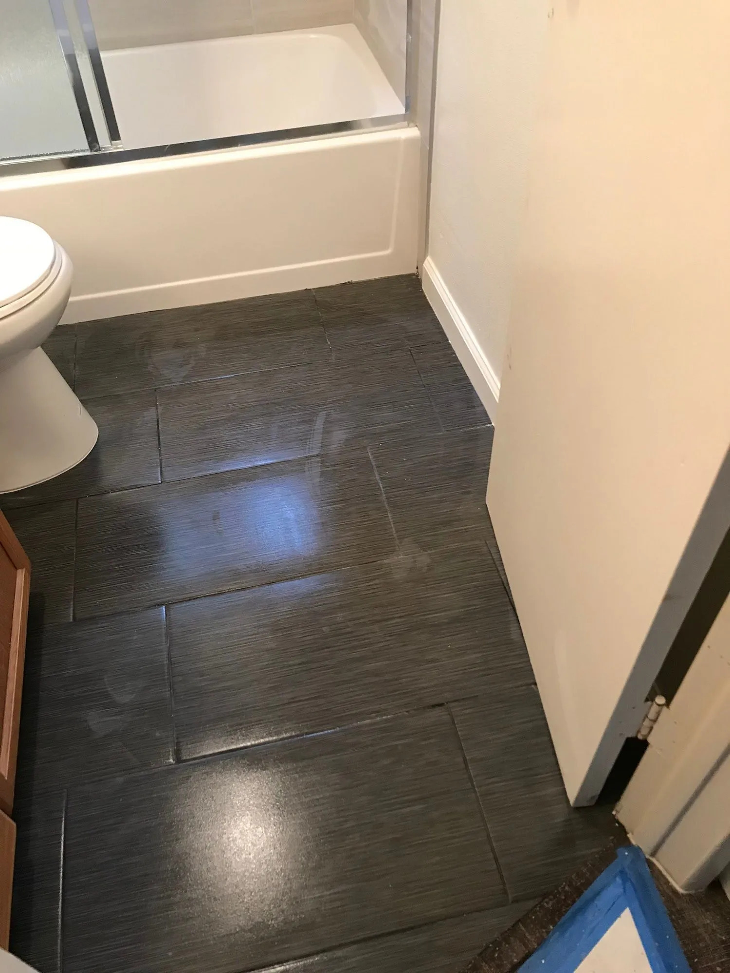 Newly installed dark porcelain floor tiles enhance this bathroom with a sleek contemporary appearanc 