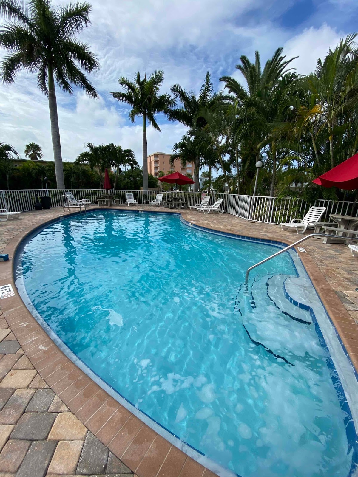 Resort-style swimming pool with curved entry steps, palm trees, stone paver decking, and tropical outdoor seating areas.
Select 82 more words to run Humanizer.
