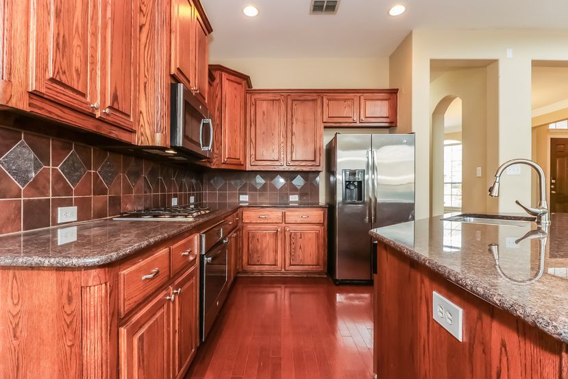 Stunning kitchen with granite countertops and stainless steel appliances at Invitation Homes Houston.