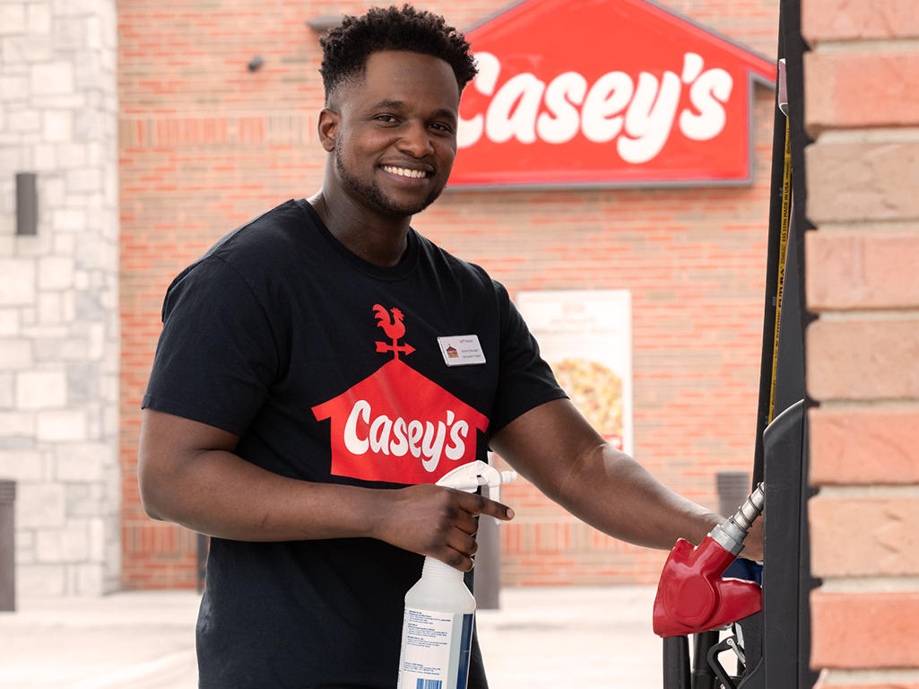 Casey's team member cleaning gas pumps