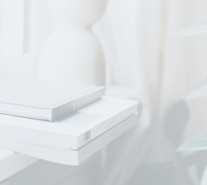 Stacked coffee table books next to a house plant.