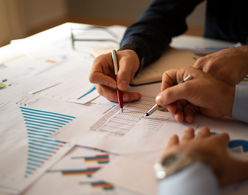 A close up of a pair of advisors looking over graphs and documents.