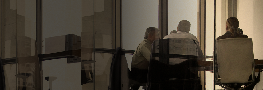 Professionals working around a boardroom table.
