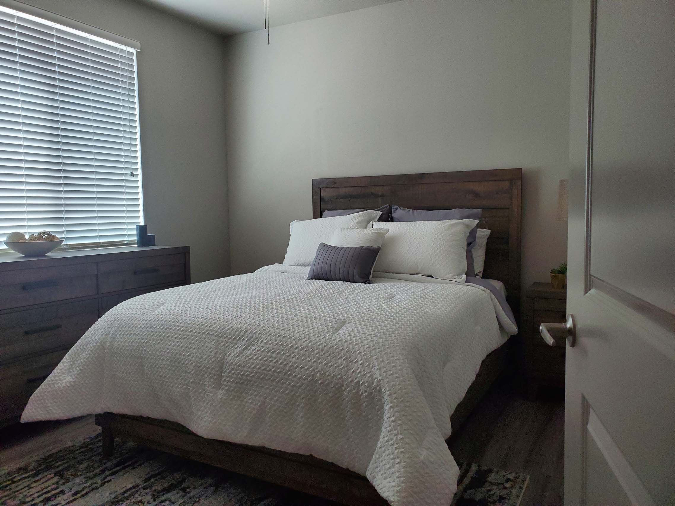 Bedroom with wooden furniture and white bedding