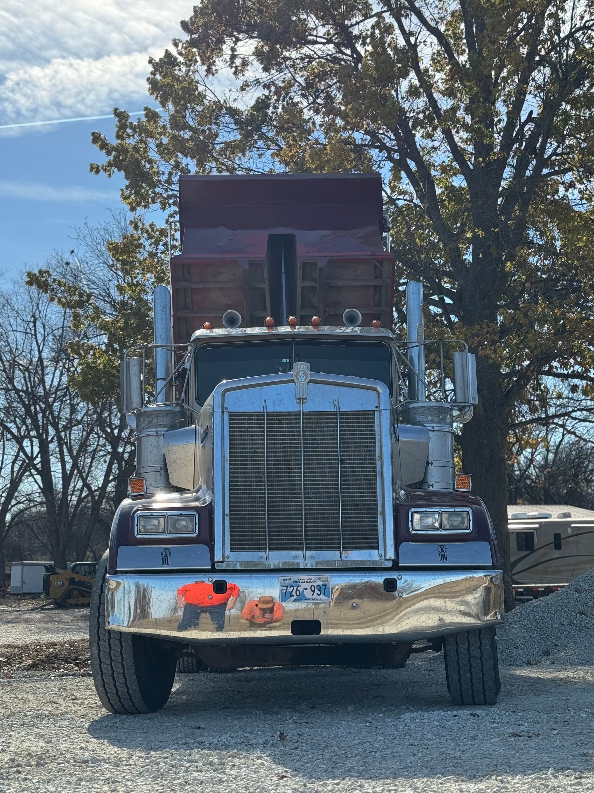 L & R Logistics LLC heavy-duty dump truck photographed from the front, featuring a raised dark bed, chrome grille, large tires, and rugged construction hauling equipment outdoors locally in Oklahoma.