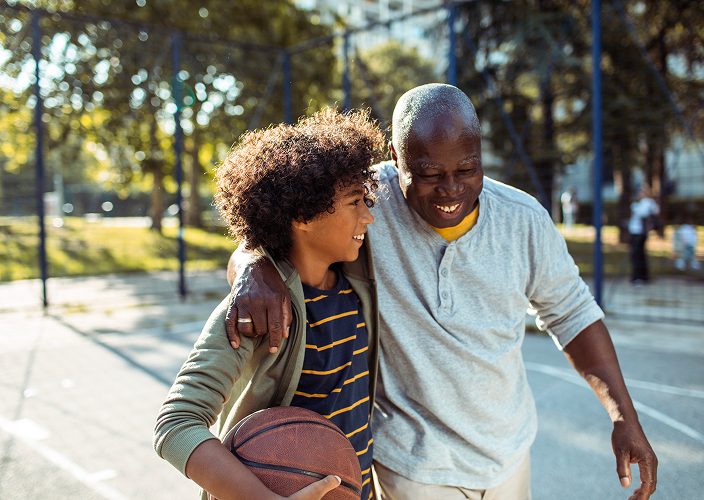 A father and son playing basketball.