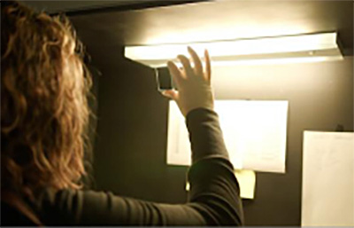 Technician conducting detailed optical performance testing and inspection of thin film coatings. DSI's comprehensive testing protocols verify spectral transmission/reflection characteristics, laser damage thresholds (up to 25 MW/cm²), and environmental durability to ensure space-qualified and military-specification compliance for mission-critical applications.
