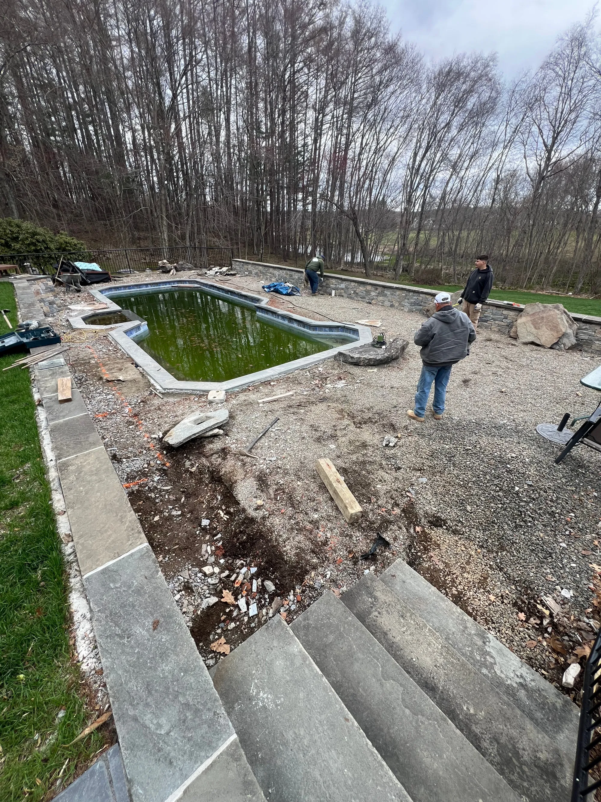 Bare pool deck prepared for drainage work - Excavation, Drainage & Site Prep project by General Masonry LLC.