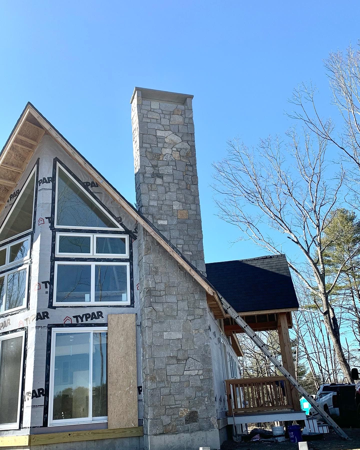 Custom natural stone chimney built by Mac's Masonry, featuring expertly crafted granite stonework that complements the home's architecture while providing lasting durability and weather resistance.