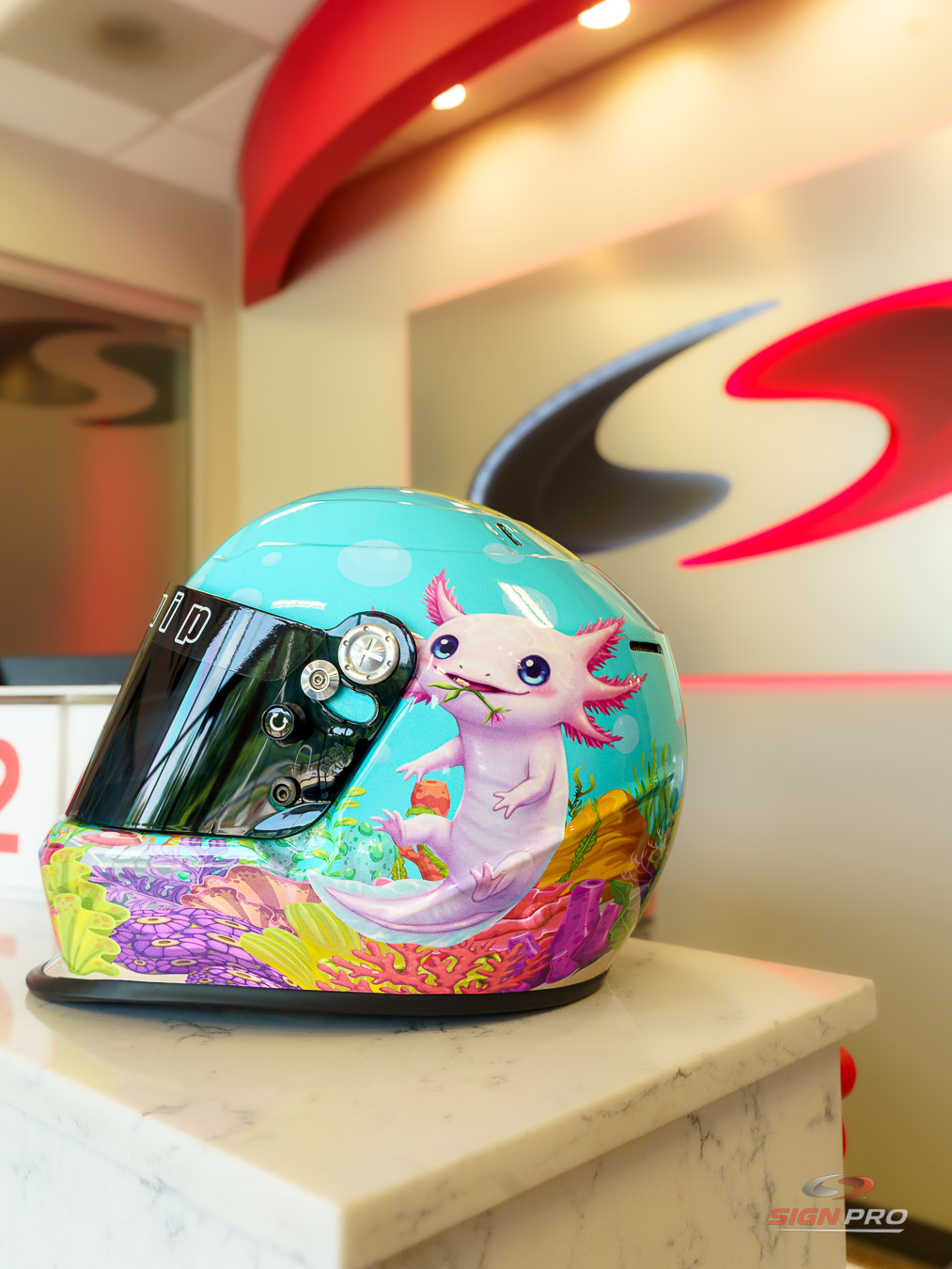 Custom-wrapped racing helmet produced by Sign Pro, featuring a vibrant underwater-themed design with detailed graphics and professional vinyl application.