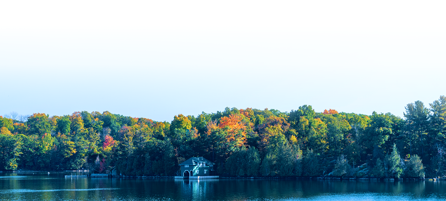 Cottage on a lake with autumn foliage.