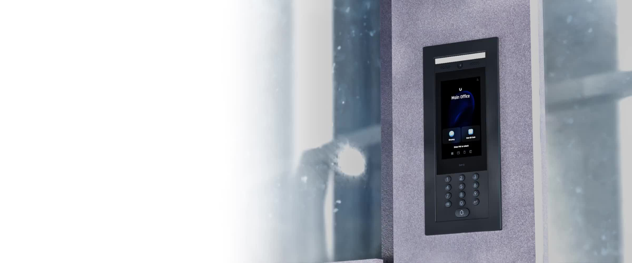A modern intercom system with a touch screen and keypad is mounted on a textured gray wall. The screen displays "Main Office" along with icons for "Directory" and "Scan QR Code," and prompts the user to "Enter PIN to Unlock." Below the screen is a numeric keypad and a call button. To the left, a blurred window shows a reflection of the interior, suggesting an office or building entrance.