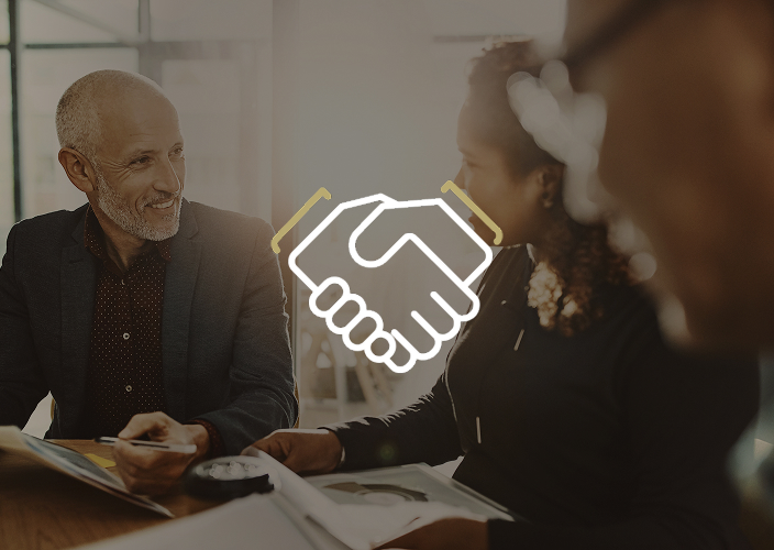 A professional meeting with two clients and going over paperwork.