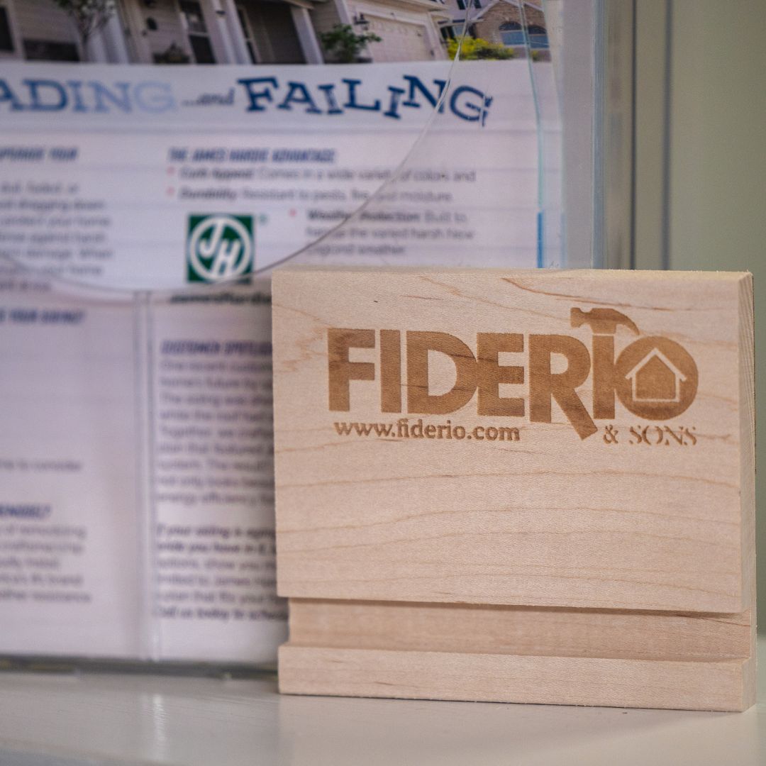 Fiderio & Sons’ logo engraved on a maple wood sample, displayed at the design center.