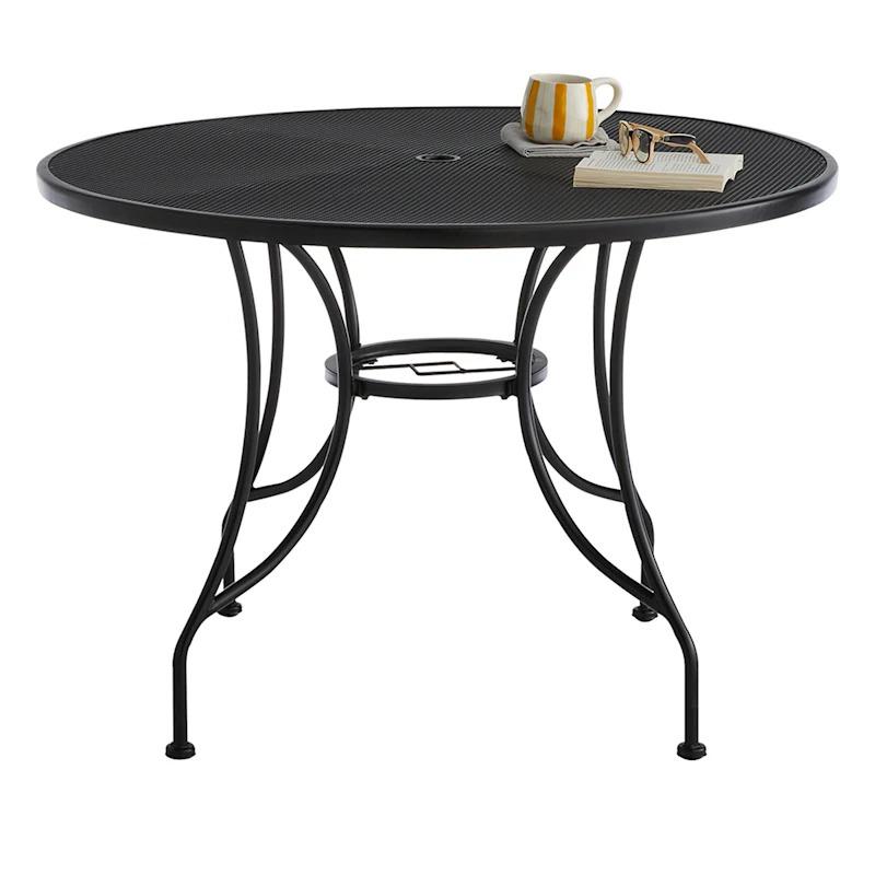 A round wrought iron outdoor dining table, perfect for al fresco dining or gathering with friends and family in the backyard or patio.