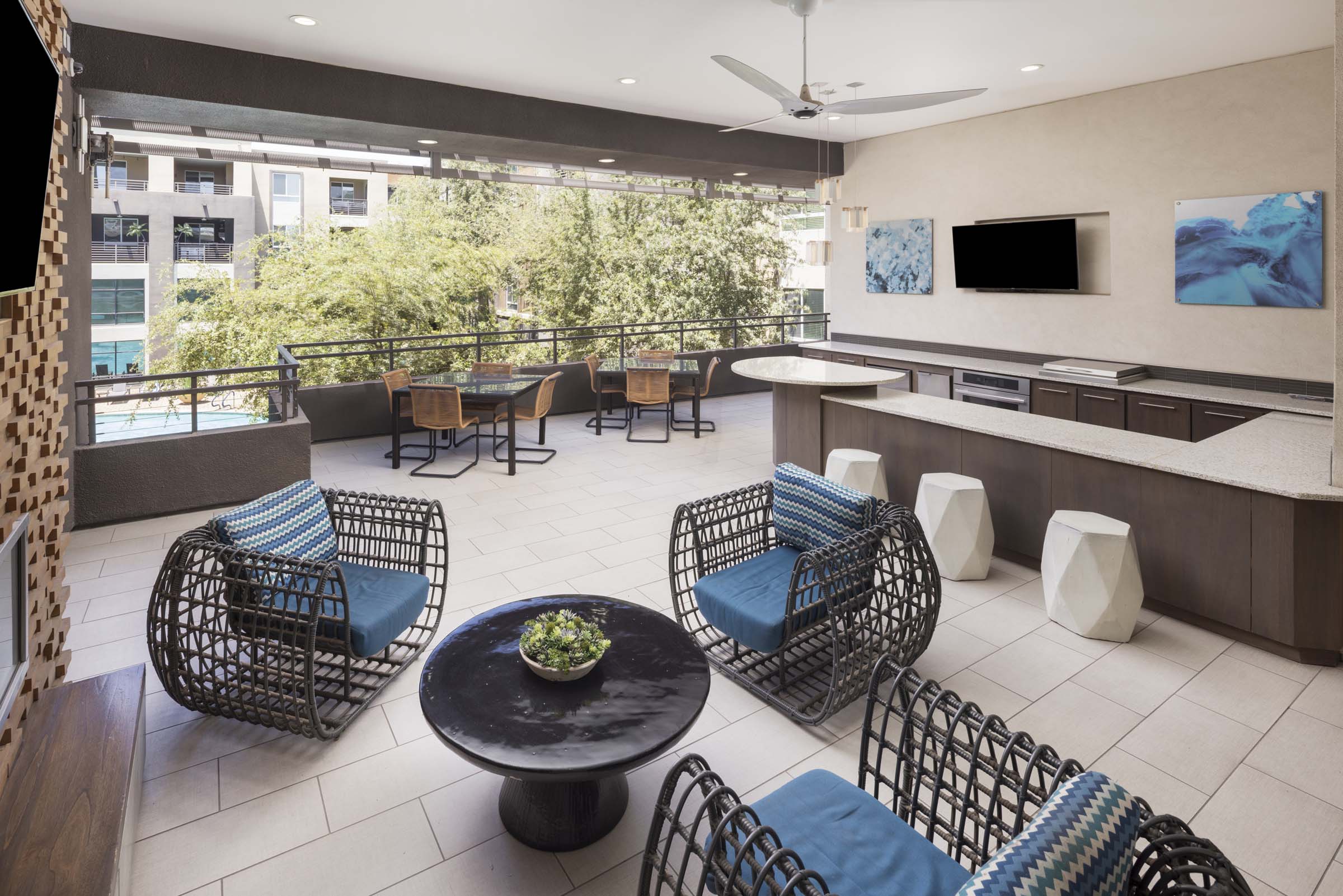 Second floor resident lounge outdoor kitchen and lounge area with TVs overlooking the pool at Camden Tempe apartments in Tempe, AZ
