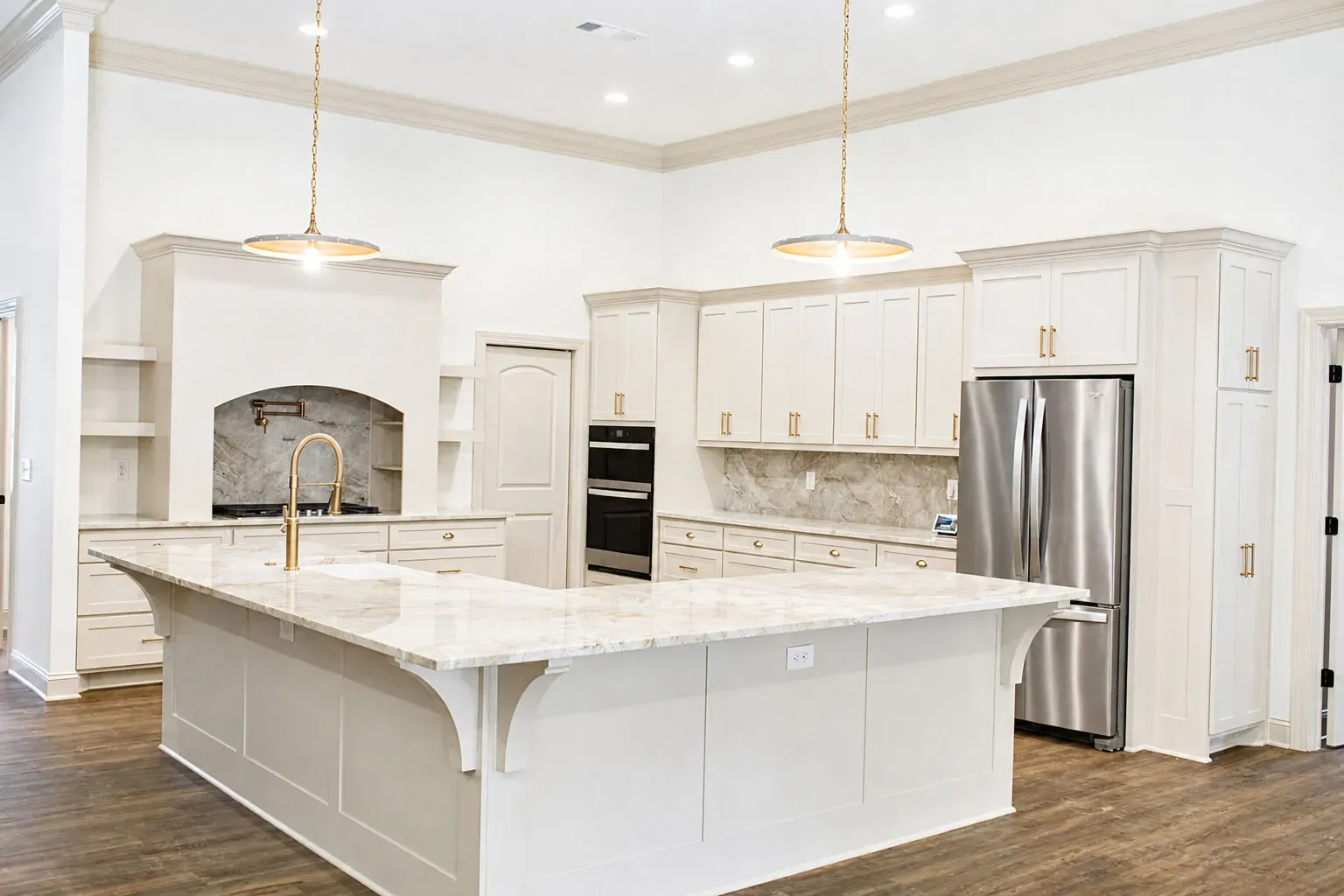Chef’s Kitchen with Waterfall Island: Features a massive, striking waterfall quartzite kitchen island, a custom range hood, and premium gold pendant lighting.