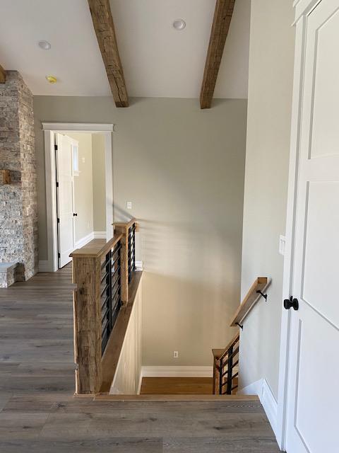 Hand hewn wood ceiling beams are used for a beautiful ceiling statement.
Staircase newel post are solid Reclaimed Wood oak barn beams with black iron balusters.