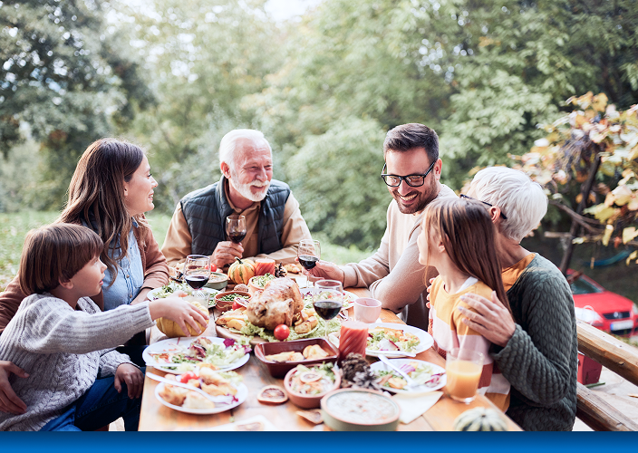 A multigenerational family enjoying a meal outside.