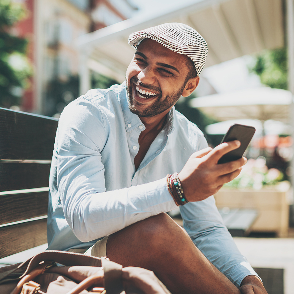 A man sitting on a bench holding a phone