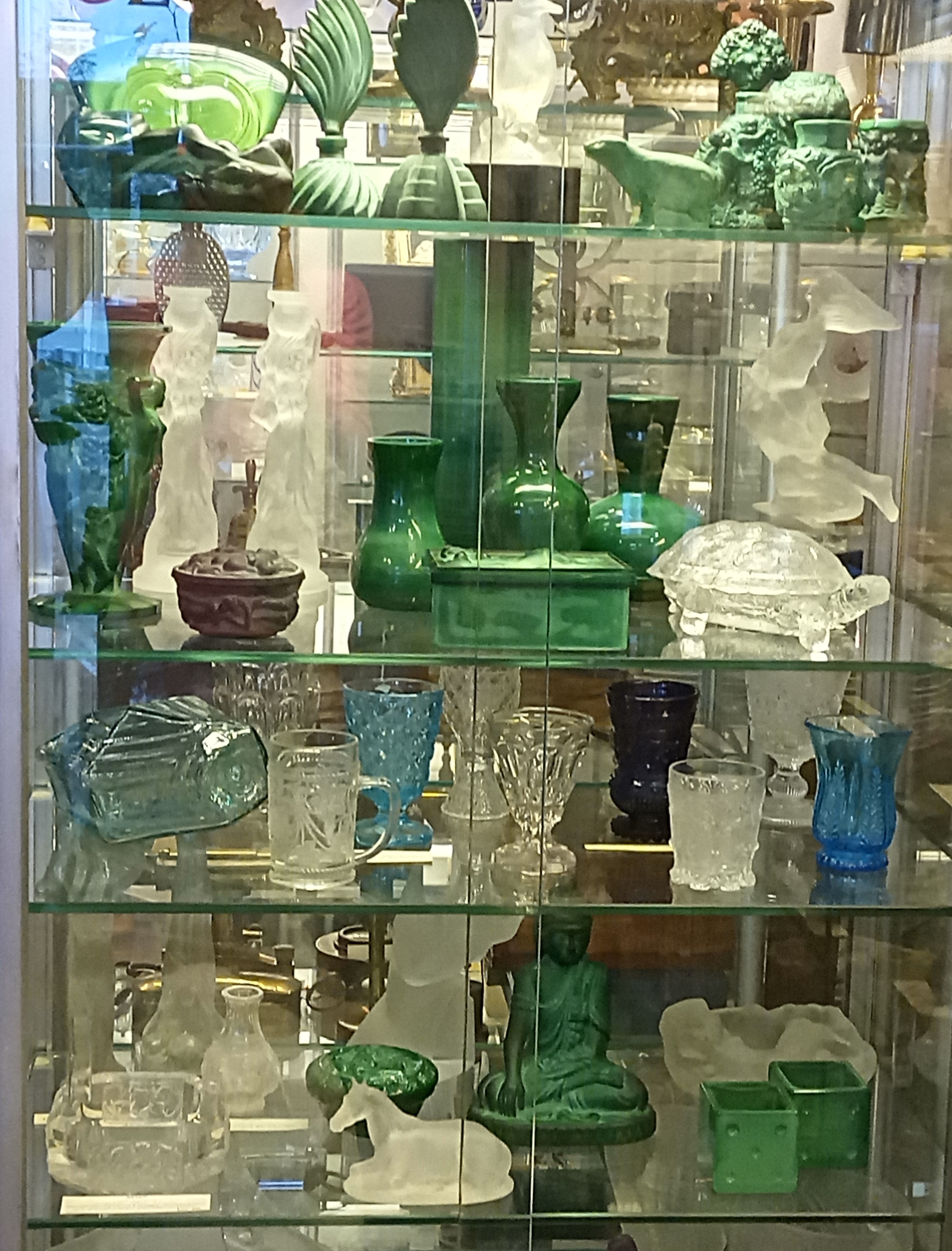 Vielseitiges Glassortiment der Antiquitäten Beyer im Zentrum Münchens - Bunte Gläser, Figuren und vieles mehr