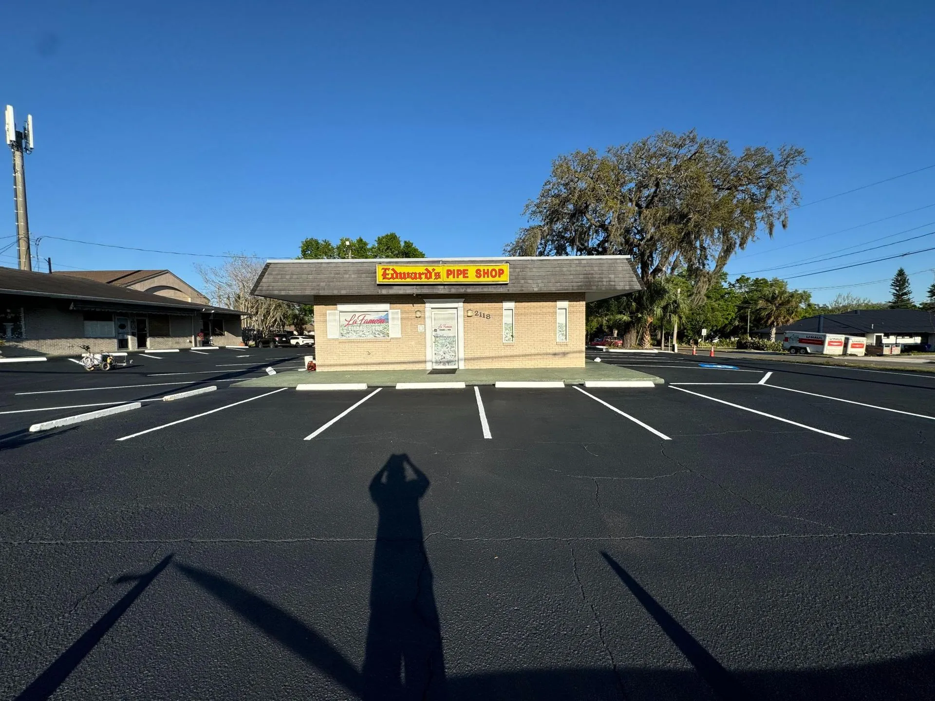 Commercial building surrounded by newly striped parking spaces and refreshed asphalt surfaces, demonstrating professional parking lot maintenance services.