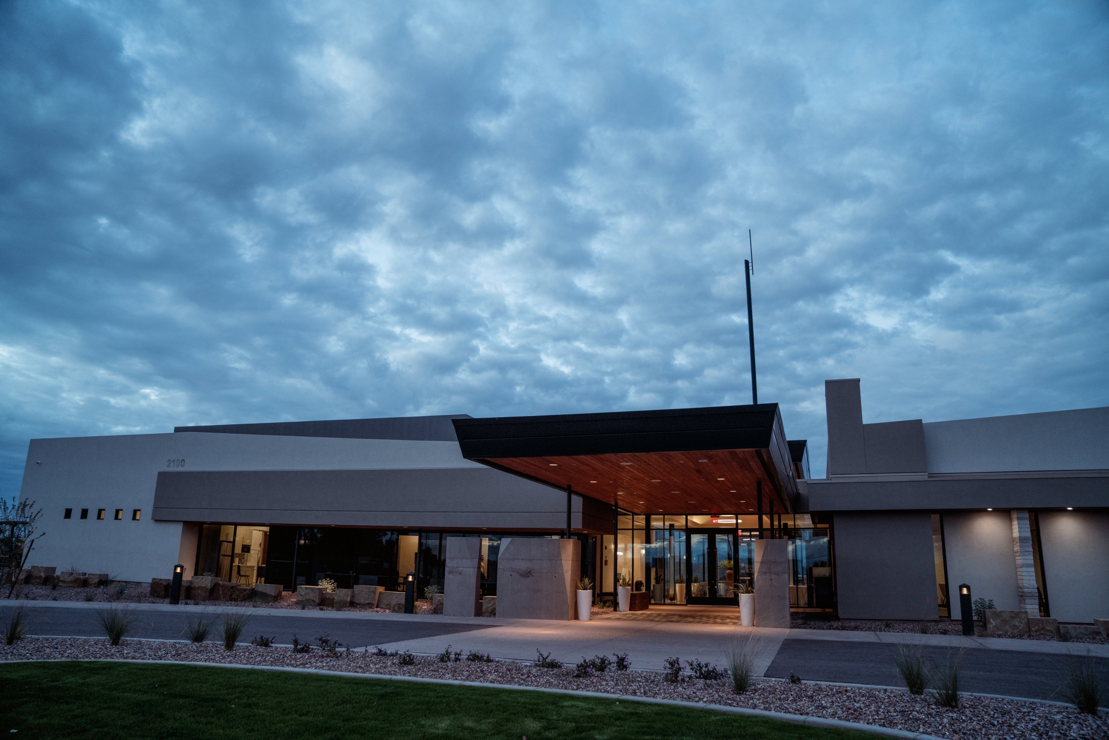 The front of the Gilbert Memorial Park building and entrance canopy at dusk.