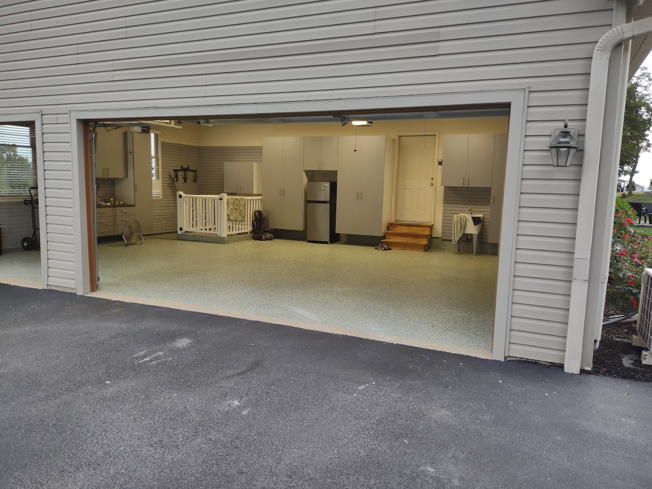 Custom Garage makeover includes new lighting, duel Custom Epoxy flake floor finishes to match interior and exterior of the house.  Wall-to-wall slatwall.  Custom garage cabinets.  Bluetooth enabled multi bike overhead storage.