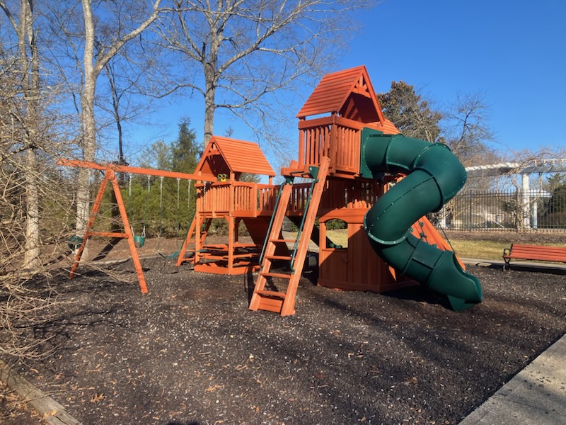 Cedar wood residential playset with green tube slide.