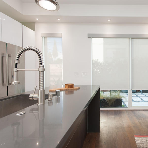 With custom roller shades, you can get maximum coverage on doors and windows - no matter what size they are. These translucent roller shades complement this kitchen's sleek look while maintaining outdoor visibility.