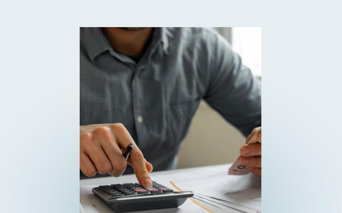 Close-up of a person using a calculator.