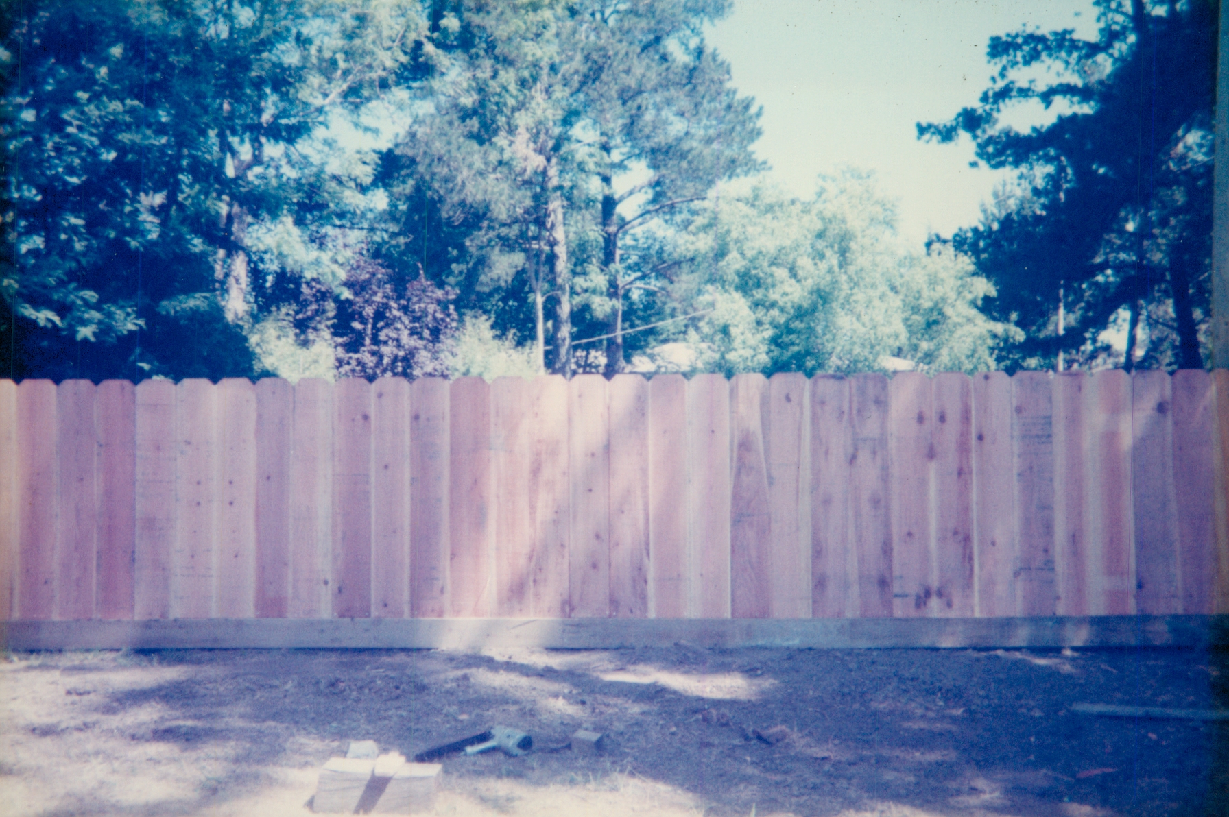 Tall wood privacy fence installed along a backyard to create a secure and private outdoor space.