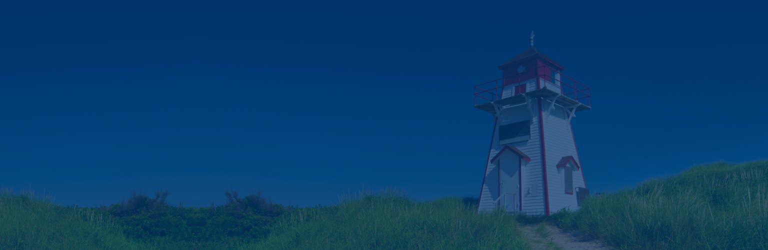 Red and white lighthouse on a grassy plain against a bright blue sky.