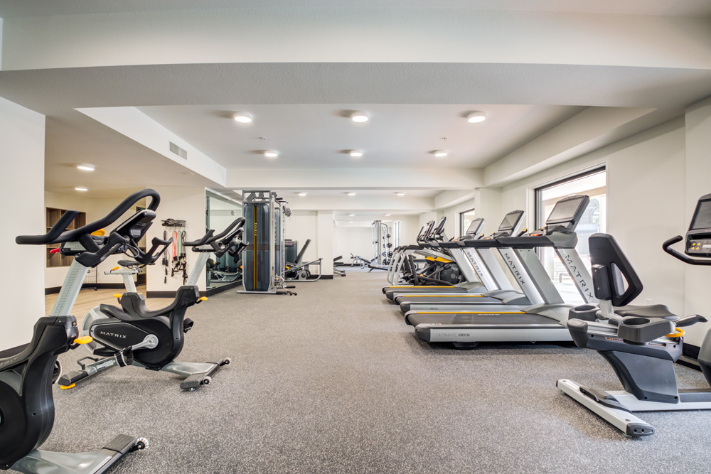 Fitness center with cardio machines, weight machines, free weights, and yoga room.