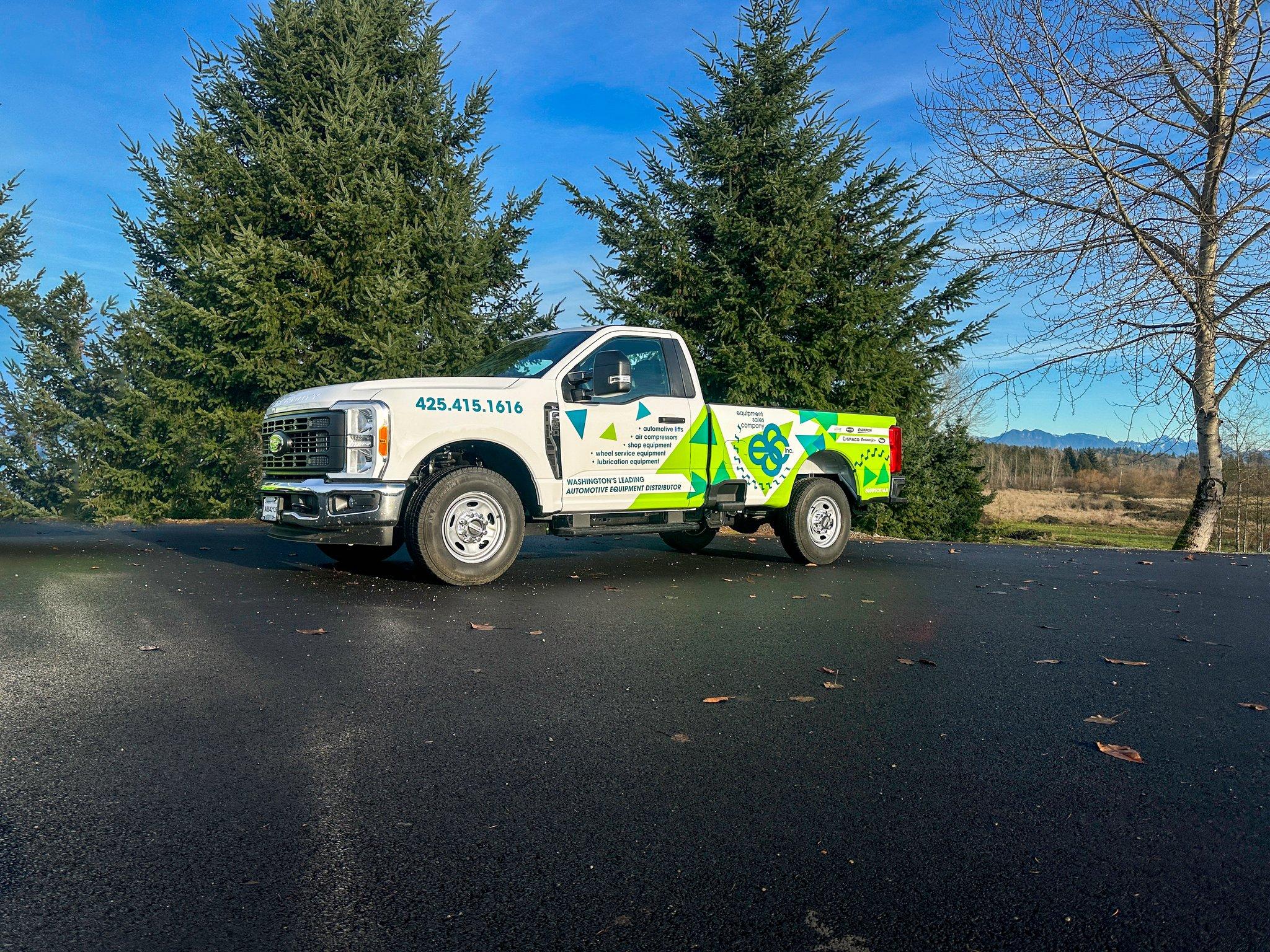 Partial truck wrap on a Ford Super Duty for Equipment Sales Company, mixing bold graphics with the truck's white paint.