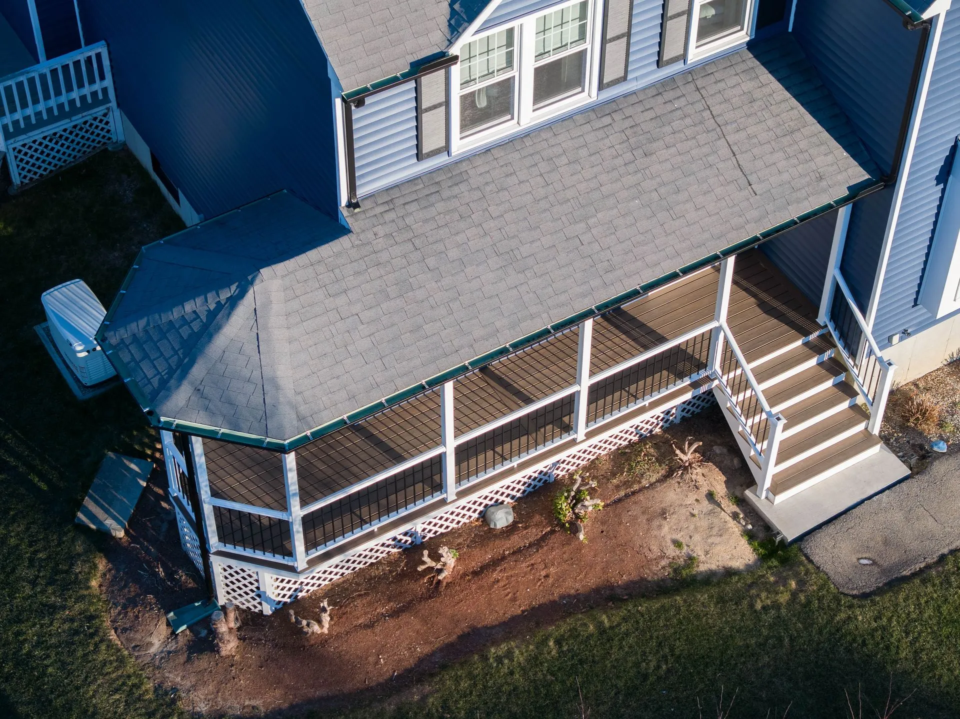 Aerial photograph of a covered deck featuring gutters along multiple roof sections. Proper drainage  