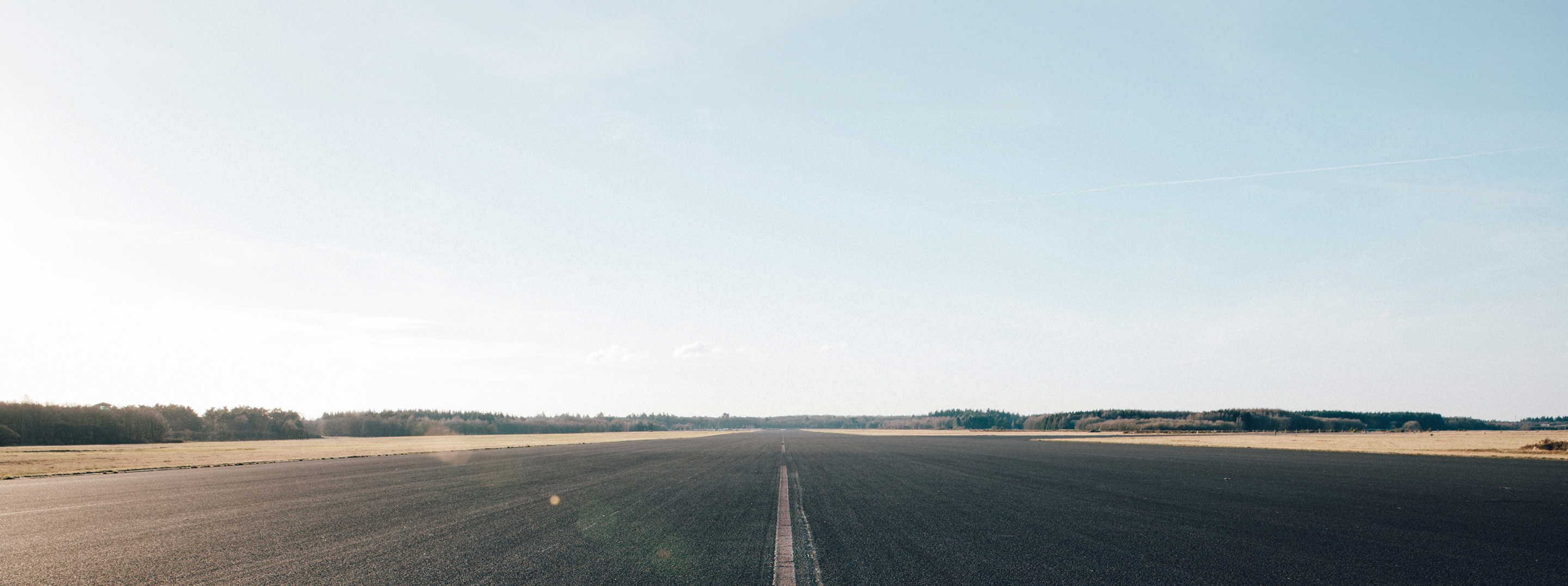 An open road surrounded by fields.