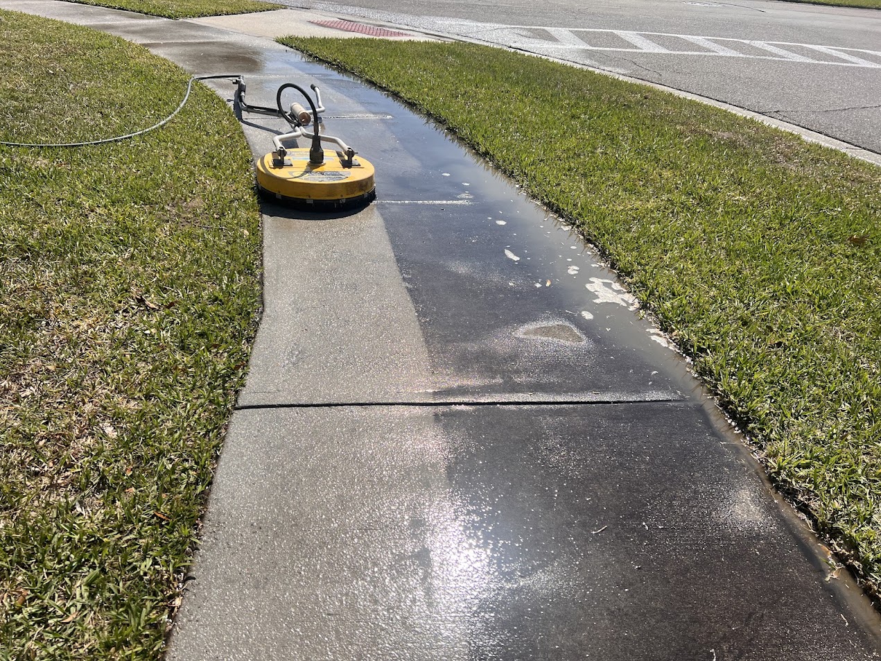 Professional sidewalk pressure washing in Kissimmee, FL, removing dirt, algae, mildew, and buildup from concrete walkways.