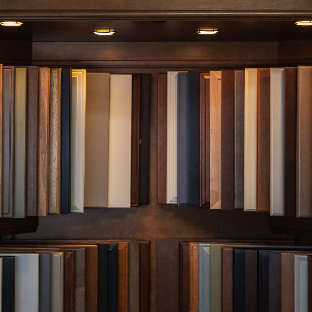 Floor-to-ceiling cabinet finish samples organized by tone and texture in the design studio.