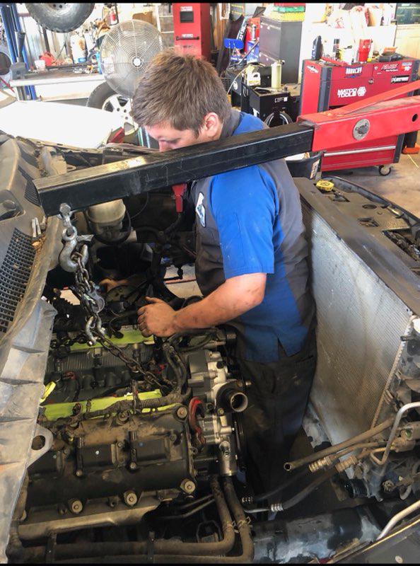 C H Auto Repair mechanics working on a vehicle.