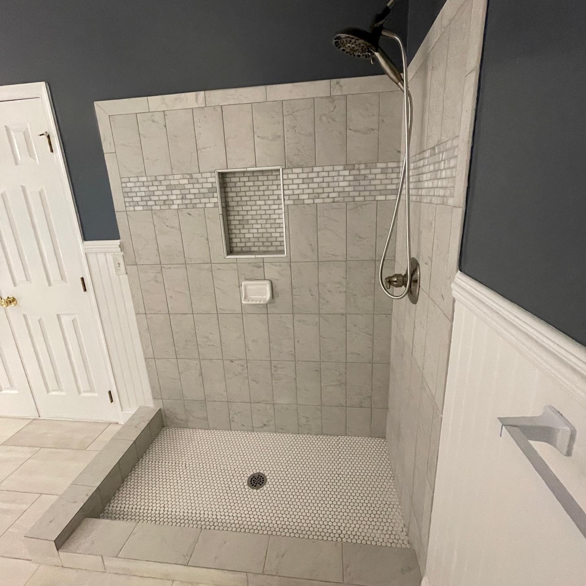 Elegant shower renovation featuring a built-in rainfall showerhead, premium beige tiles, and a modern glass enclosure. Designed for a spa-like experience at home.