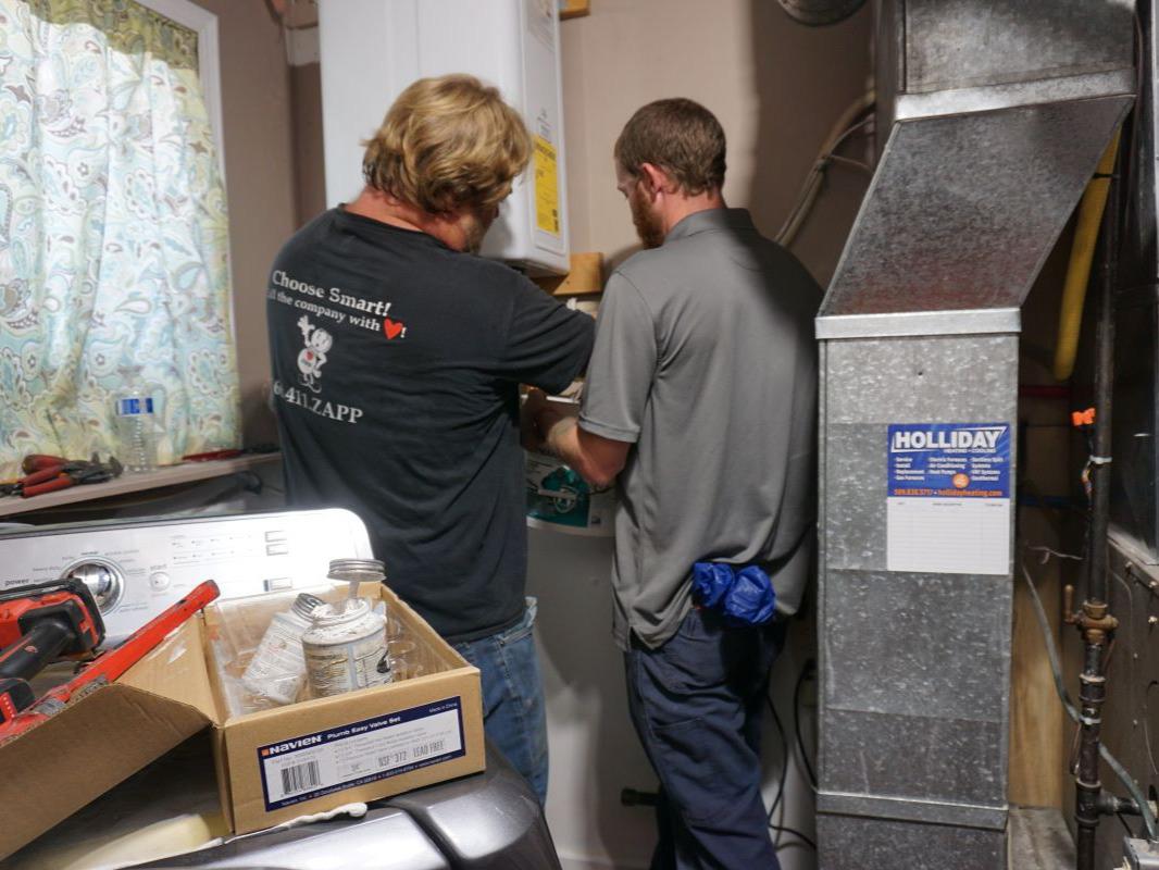 Plumbers installing a hot water heater