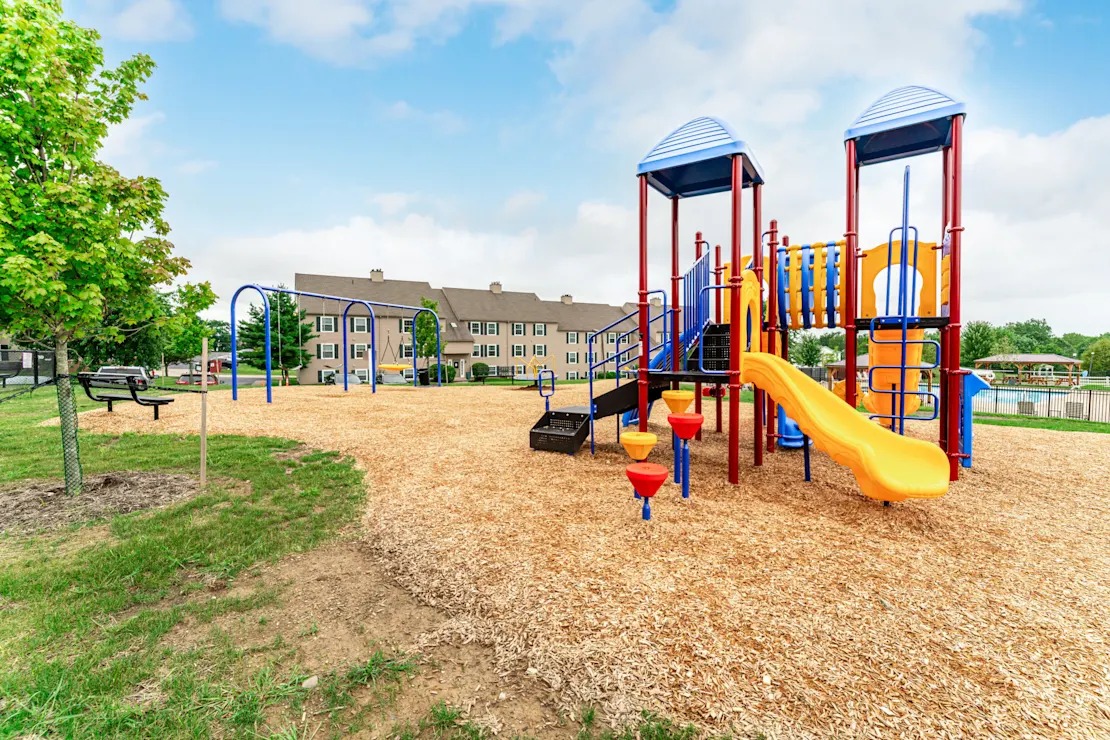 A playground with a yellow slide and blue towers.