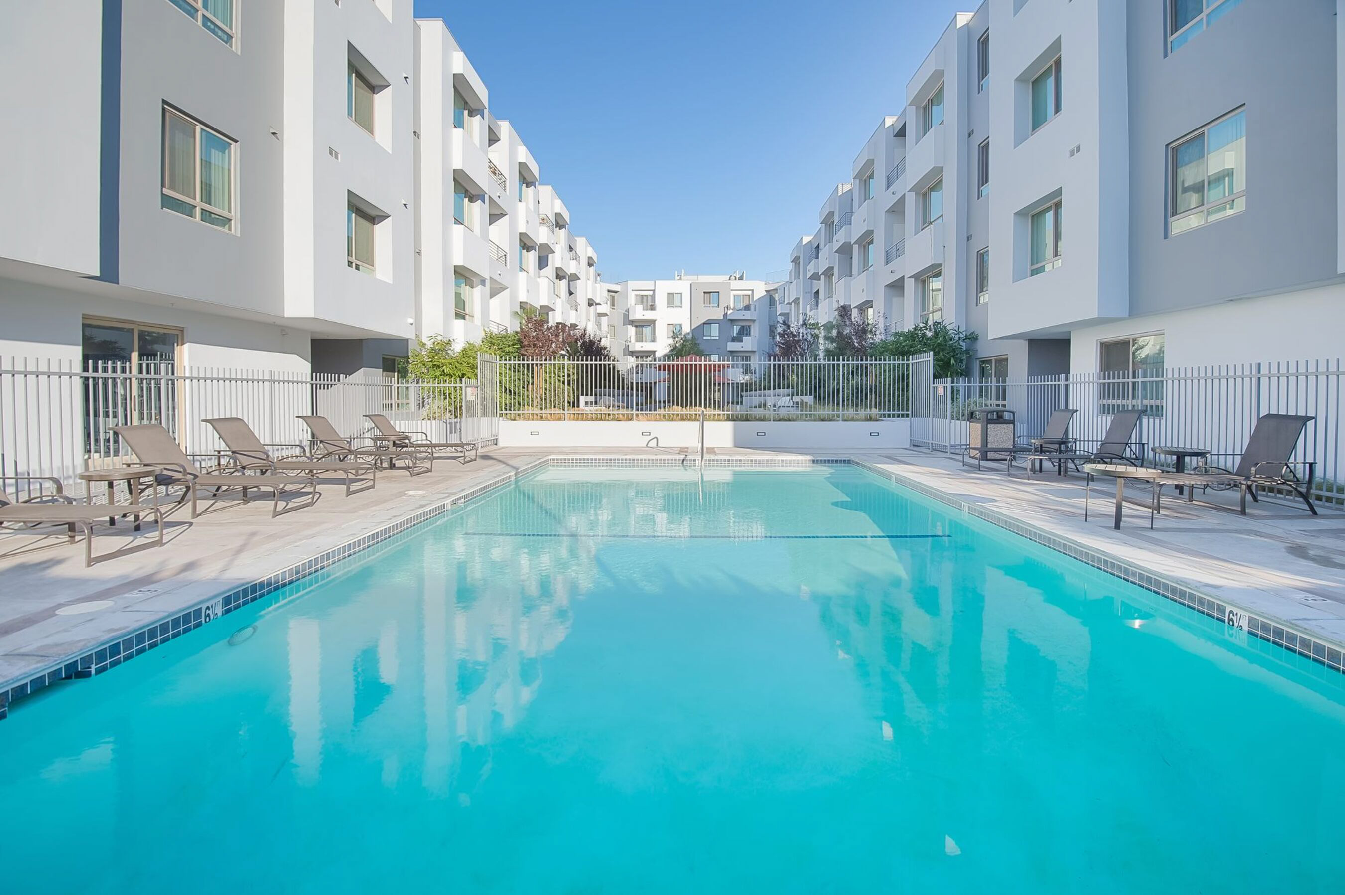 A swimming pool in front of apartment buildings.