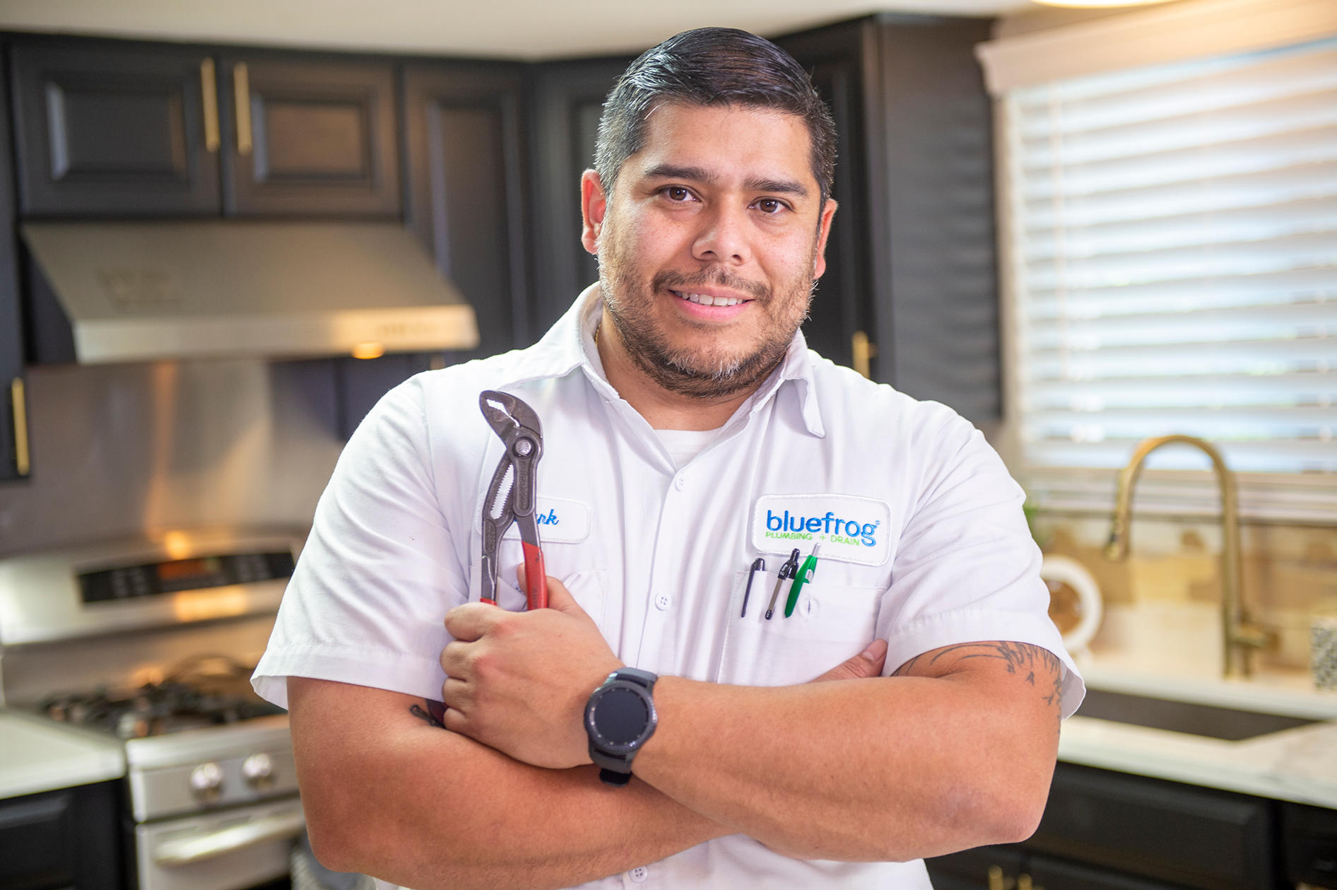 Plumber technician working in the kitchen. Plumbing Company Serving Katy, Sugar Land, Memorial City, Houston.